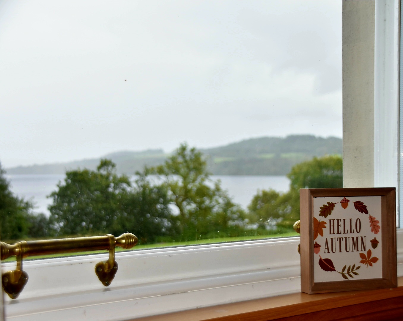 A Hello Autumn sign in the window overlooking Loch Lomond